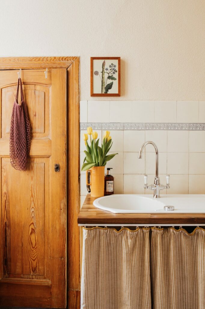 Naturmaterialien im biophilen Design: Holztür, Tulpen und botanische Kunst in der Küche