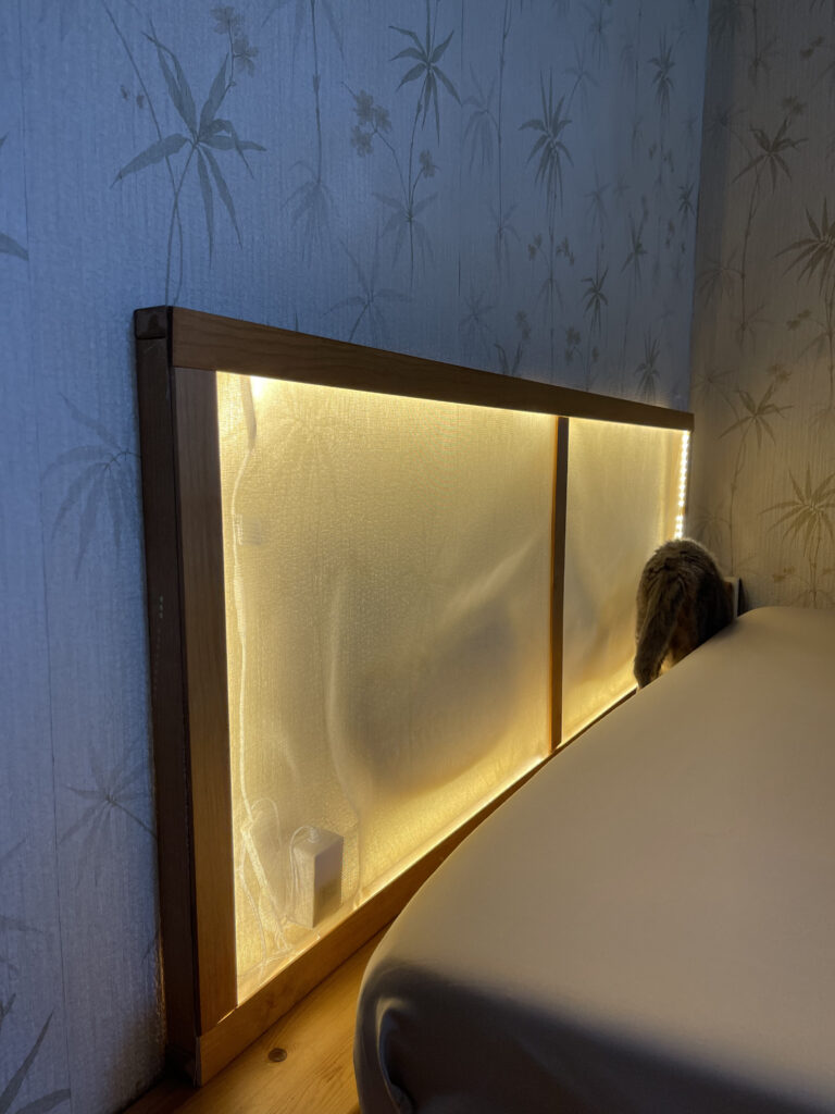 Schlafzimmer mit beleuchtetem Kopfteil im Japandi-Stil